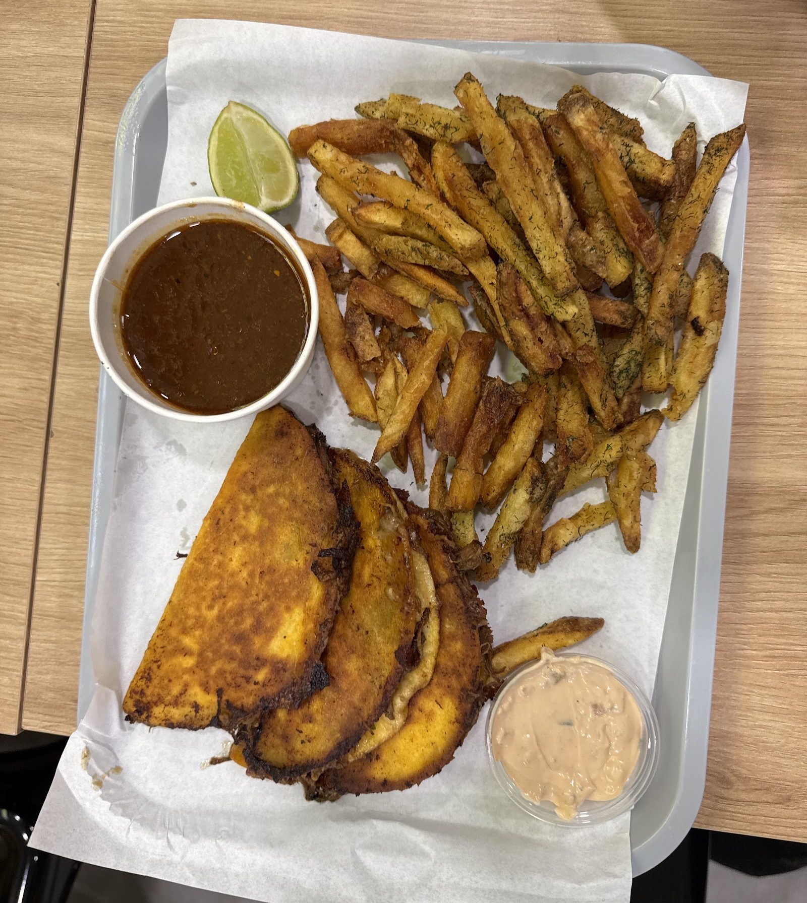 Tablett von oben: Birria Tacos, Fries, Consommé, Dip und Limette